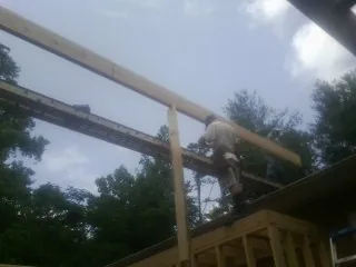 Carpenter setting a ridge beam over a new addition frame — Ice Dam Removal by Roofing Brothers in Usk