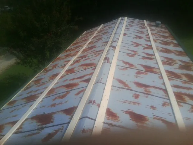 Rusted metal roof panels with new wood purlins before replacement — Storm Damage Roof Repair in Usk by Roofing Brothers