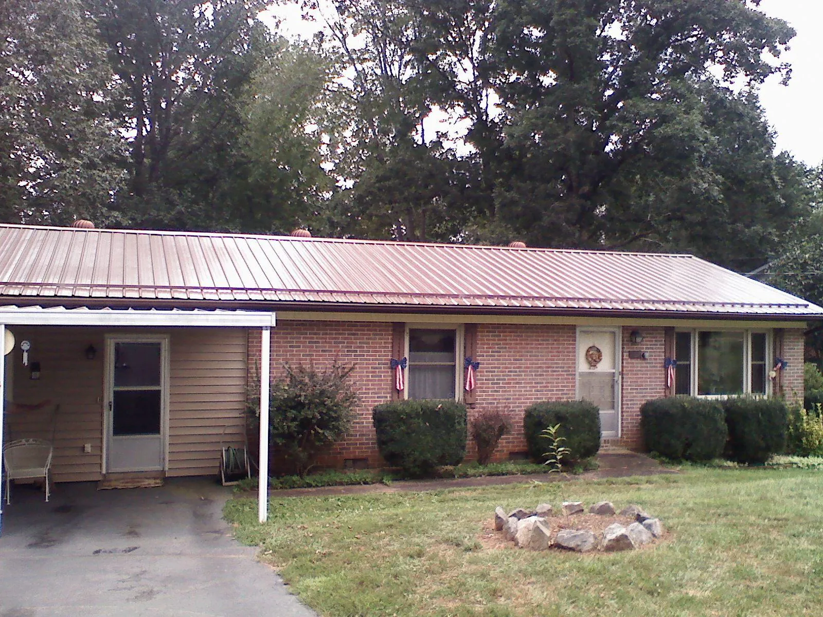 Bronze metal roof and carport on a brick ranch home — Roof Repair work by our crew in Usk